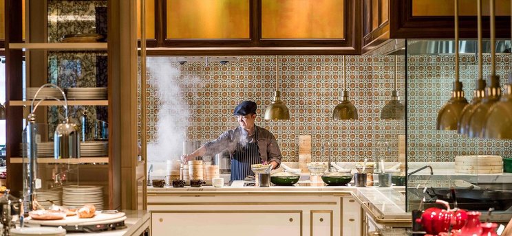 A chef cooking at an open kitchen in an IHG luxury hotel restaurant
